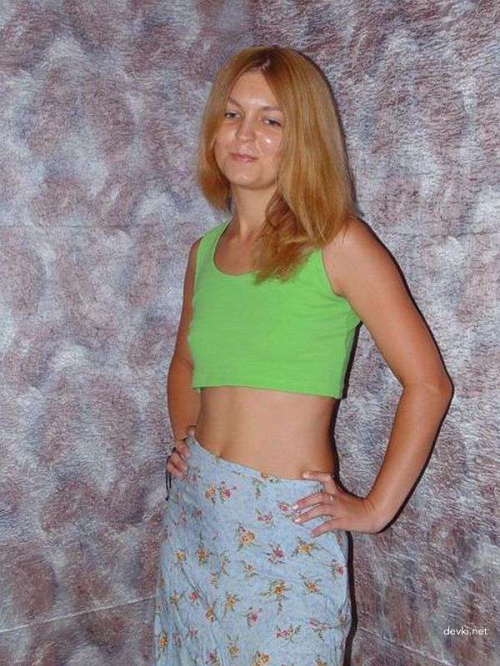 Young slender girl undresses on the bed.
