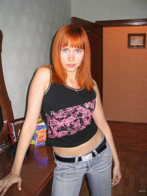 Explicit Home Photo of Busty Redhead Woman - Seductive Pose and Sultry Look